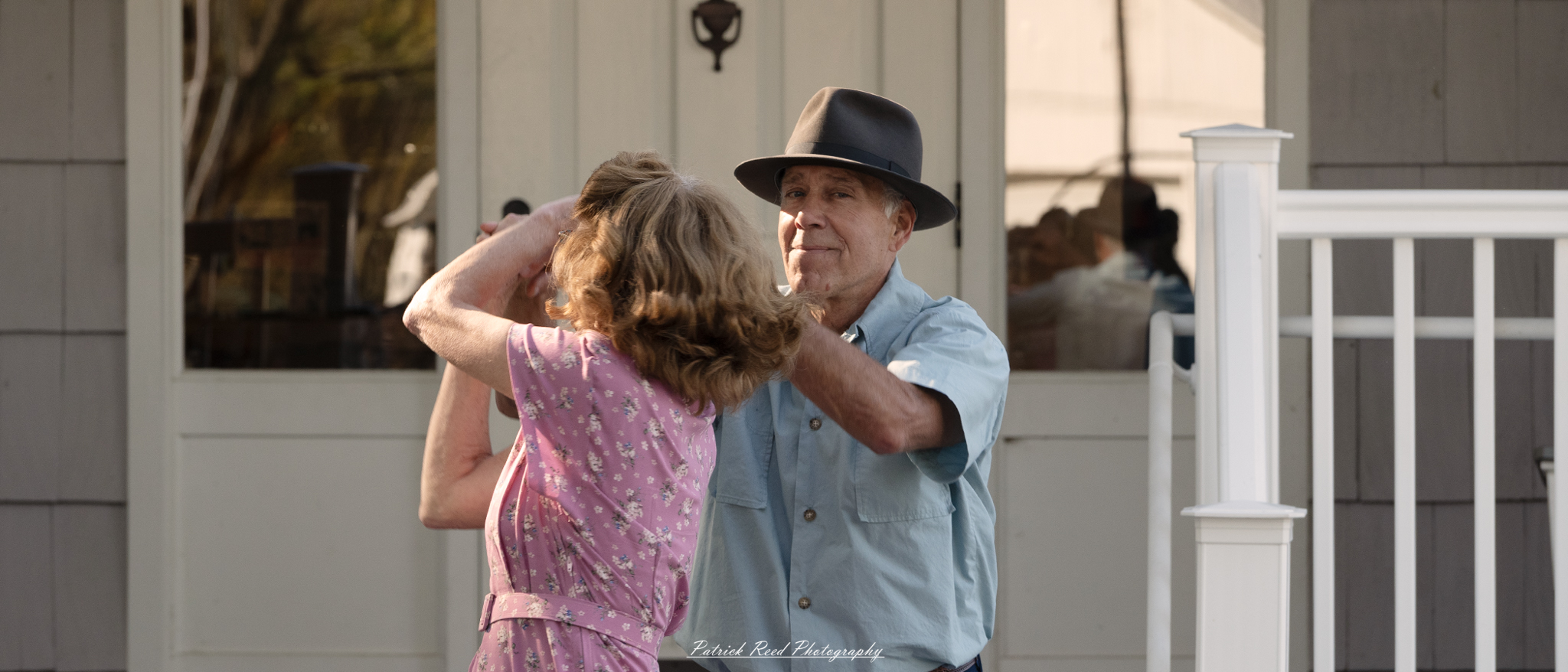 "A couple dancing in 1940s clothing, the man in a classic suit and tie, and the woman in a vintage dress with elegant waves in her hair. They share a joyful moment, moving gracefully across the dance floor, capturing the charm and elegance of the era. The scene is nostalgic, filled with the romance and swing music style that defined the 1940s."